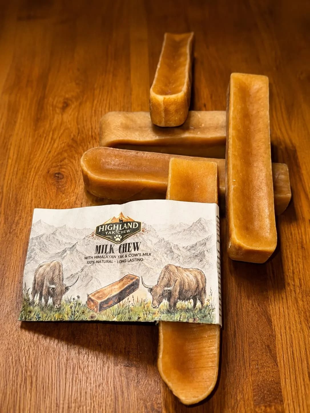 Natural Himalayan yak chews beside a Highland Yak Chew pack illustrated with yaks and mountains