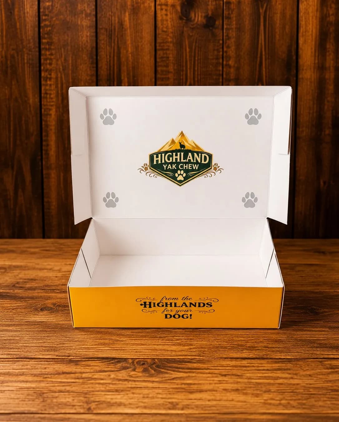 Open white and yellow Highland Yak Chew gift box with paw prints, printed “from the Highlands to your dog”